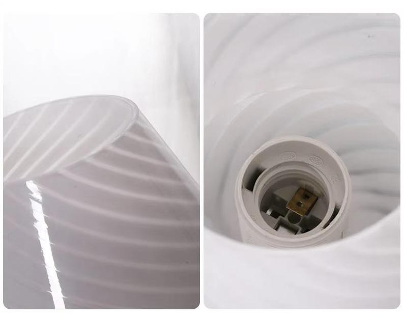 May include: A white glass lampshade with a swirled design. The lampshade has a bulb socket inside. The glass has a translucent quality, allowing light to pass through. The lampshade is designed for use with a light bulb.
