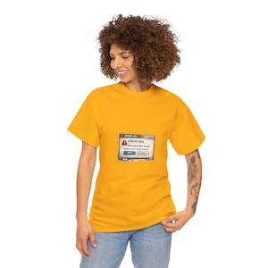 May include: Mustard yellow t-shirt with a computer error message graphic. The graphic reads "ERROR 404 Motivation Not Found. Would you like to sleep instead?" with "Yes" and "Cancel" buttons. The shirt is worn by a person.