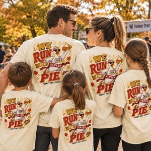 May include: A beige t-shirt featuring a graphic of a goose wearing sunglasses and a headband, holding a slice of pie. The text reads WE RUN FOR PIE and TURKEY TROT FAMILY, with the number 2026 on the goose's bib, surrounded by autumn leaves.