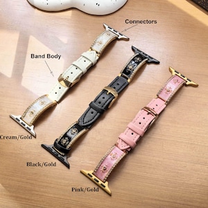 K&ouml;nnte beinhalten: Drei Uhrenarmb&auml;nder mit Metallanschl&uuml;ssen und Schnallen. Die B&auml;nder sind cremefarben, schwarz und rosa und verf&uuml;gen jeweils &uuml;ber eine mittlere Reihe goldfarbener sonnenf&ouml;rmiger Verzierungen und seitliche Akzente. Beschriftungen zeigen Band Body, Connectors, Cream/Gold, Black/Gold und Pink/Gold.