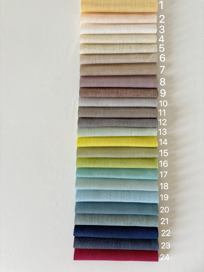 May include: A selection of 24 fabric swatches in a vertical arrangement, numbered 1 to 24. The colour palette includes shades from pale yellow and blush pink to navy and burgundy. Each swatch is a folded rectangle, displaying the fabric's texture.