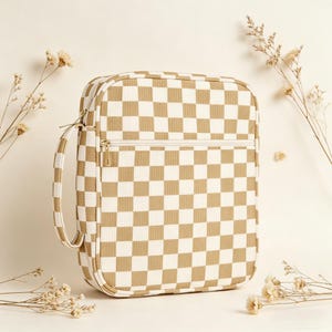 May include: A beige and white checkered pattern bag with a zipper closure and a handle. The bag has a rectangular shape with rounded corners. The bag is made of a textured material.