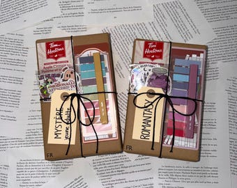May include: Two rectangular packages wrapped in brown paper, each featuring a Tim Hortons logo, a sticker, a set of coloured sticky notes, and a pen. One package is labelled "MYSTÈRE jeune adulte" and the other "ROMANTASY," both tied with black string.