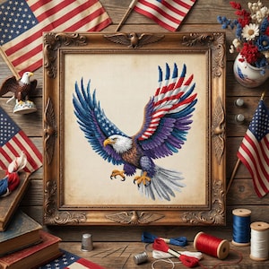 May include: A framed cross-stitch of an American bald eagle with wings spread, featuring red, white, and blue colors. The eagle is surrounded by American flags, spools of thread, and other patriotic items, creating a themed display.