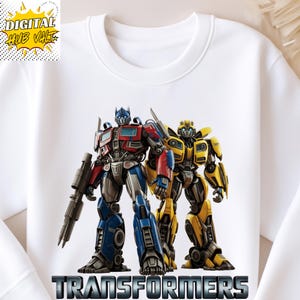 Puede incluir: Sudadera blanca con un gráfico de Optimus Prime y Bumblebee de Transformers. Los robots son de color rojo, azul y amarillo. La palabra "TRANSFORMERS" está impresa en letras plateadas en la parte inferior.