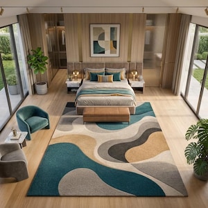 Könnte beinhalten: Ein großer rechteckiger Teppich mit einem abstrakten Muster aus fließenden, organischen Formen in den Farben Petrol, Beige, Anthrazit und Creme. Der Teppich liegt in einem Schlafzimmer mit hellem Holzboden, einem Bett und zwei Sesseln.