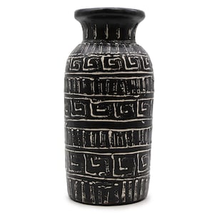 May include: A black ceramic vase with a white geometric pattern. The vase has a wide base, a cylindrical body, and a narrow neck with a flared rim. The design is reminiscent of ancient pottery. The vase is approximately 30 cm tall.