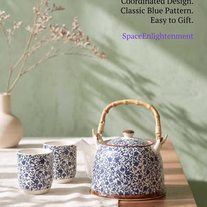 May include: A ceramic teapot and two matching cups featuring a blue and white floral pattern, a bamboo handle, and a lid. Text reads: A visually cohesive ritual that elevates every pour. Coordinated Design. Classic Blue Pattern. Easy to Gift. SpaceEnlightenment.