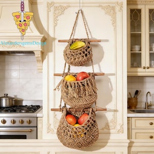 May include: A three-tiered hanging fruit basket made of woven natural fibers. Each basket is filled with colorful fruits, including red and yellow apples and a star fruit. The baskets are suspended from a wooden dowel and rope.