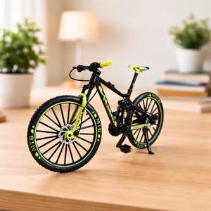 Könnte beinhalten: Ein Miniatur-Mountainbike in Schwarz und Gelb mit den Buchstaben "MTB" auf den Reifen. Das Fahrrad hat einen gelben Sattel und Lenker. Das Fahrrad steht auf einer Holzoberfläche.