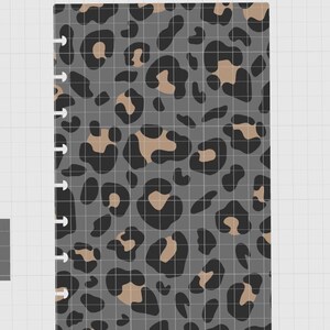 May include: A rectangular planner insert featuring a repeating leopard print pattern in shades of dark gray, black, and tan. The left edge of the paper has a series of small, evenly spaced cutouts designed for a disc-bound binding system.