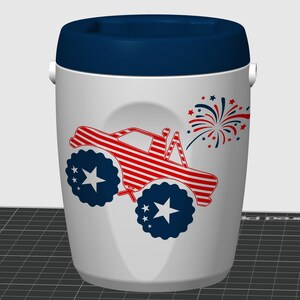 May include: A white cylindrical cooler with a dark blue lid and handle. The front features a red and white striped monster truck graphic with dark blue wheels containing white stars, accompanied by a red and blue firework burst design.