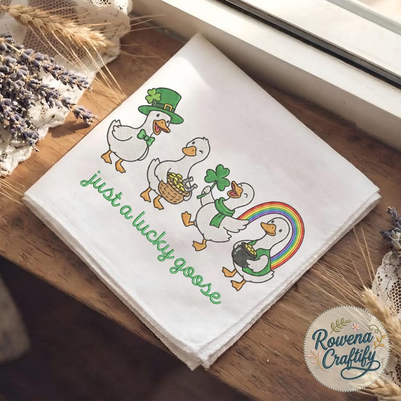 May include: White handkerchief with a St. Patrick's Day theme. Features four cartoon geese, each with a different accessory, including a green hat, basket of gold, shamrock, and rainbow. The text "just a lucky goose" is written in green.