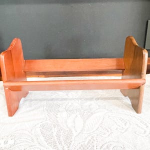 May include: A white ceramic mug with a black handle and the text "But First, Coffee" in a black, bold font. The mug is on a white surface.