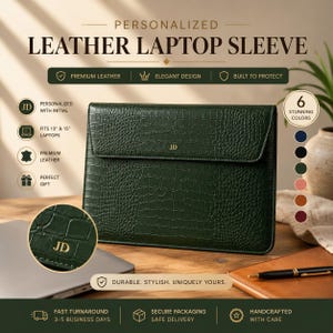 Puede incluir: Una funda para portátil de cuero verde oscuro con textura de piel de cocodrilo y cierre de solapa. El centro de la solapa presenta las iniciales JD grabadas en dorado. La funda es rectangular con esquinas redondeadas y perfil fino.