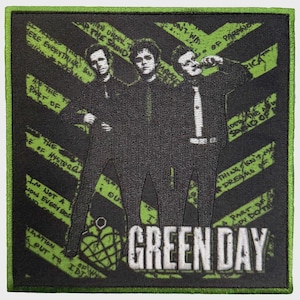 May include: A square embroidered patch featuring a black and lime green design of the band Green Day. The image shows three figures in black suits against a background of diagonal green stripes with text. The words GREEN DAY appear in white.