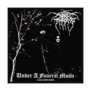 May include: Black patch featuring the band name "DARKTHRONE" in white gothic lettering. The image depicts a dark, shadowy scene with figures and the text "Under A Funeral Moon" in white. © 2010 DARKTHRONE is also visible.