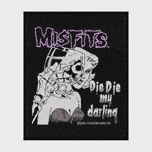 May include: A rectangular black fabric patch featuring a white graphic of a skull and a person, with the text MISFITS in purple at the top and Die Die my darling in white. The bottom includes the text 2002 CYCLOPIAN MUSIC INC in small white letters.
