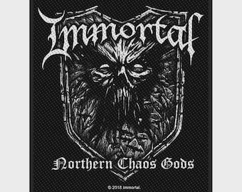 Peut inclure: Un écusson rectangulaire en tissu noir et blanc présentant le mot Immortal dans une police stylisée en haut, un graphique central sombre en forme de crâne dans un contour de bouclier, et le texte Northern Chaos Gods en bas avec 2018 Immortal.