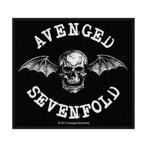 Può includere: Una toppa quadrata in tessuto nero con una grafica bianca di un teschio umano con ali di pipistrello. Il testo AVENGED è arcuato sopra il teschio e SEVENFOLD sotto. Il testo 2011 Avenged Sevenfold è stampato in piccole lettere bianche in basso.