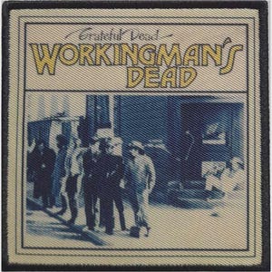 Può includere: Una toppa ricamata quadrata che riproduce la copertina dell'album Workingman's Dead dei Grateful Dead. Il design include il testo in giallo con un contorno nero, su uno sfondo color crema con una scena fotografica dai toni blu di figure.