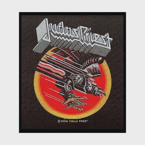 Może przedstawiać: Prostokątna, czarna haftowana naszywka z białym napisem Judas Priest nad okrągłą grafiką. Wzór przedstawia metaliczne stworzenie z pazurami w ruchu na czerwonym tle z żółtą obwódką. Na dole znajduje się napis 2004 JUDAS PRIEST.
