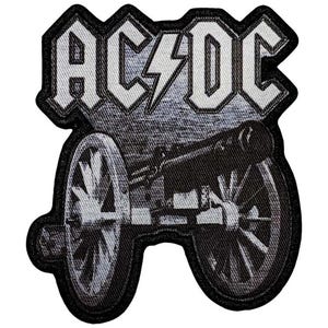 Könnte beinhalten: Ein schwarz-weiß bestickter Aufnäher mit dem Text AC/DC in einer stilisierten Schriftart und einem Blitz in der Mitte. Unter dem Text befindet sich eine detaillierte Darstellung einer alten Kanone mit zwei großen Speichenrädern in Grautönen.