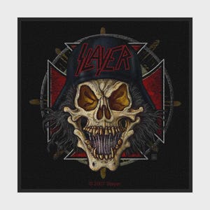 Puede incluir: Un parche de tela cuadrado con un gráfico central de una calavera sonriente que lleva una gorra negra con el logotipo rojo de Slayer. La calavera se sitúa sobre un emblema de cruz de hierro roja y negra y un fondo circular de engranaje.