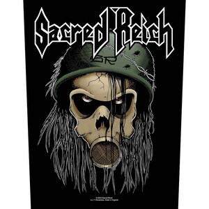 Può includere: Una toppa in tessuto nero con la scritta bianca Sacred Reich sopra l'immagine di un teschio che indossa un elmetto militare verde con filo spinato. Il teschio ha occhi rossi, lunghi capelli scuri e un filtro per maschera antigas sulla bocca.