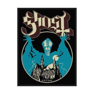 Peut inclure: Un écusson noir avec le nom du groupe "Ghost" en police gothique. Le motif comprend une silhouette bleue avec les bras tendus, une cathédrale et des éclairs, le tout dans un cercle blanc. Le texte "© 2012 Ghost" est en bas.
