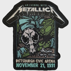 Könnte beinhalten: Ein schwarzer bestickter Aufnäher mit dem Metallica-Logo oben, dem Text An Evening With, einer Totenkopf-Illustration, dem Text Wherever I May Roam und dem Text Pittsburgh Civic Arena November 21, 1991 in weißem und hellblauem Garn.