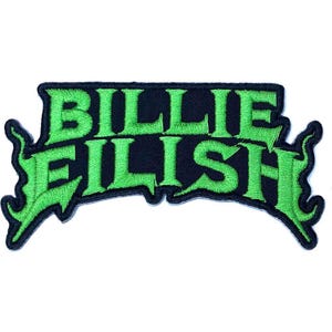 May include: An embroidered patch featuring the text BILLIE EILISH in a stylized, jagged font. The lettering is bright lime green with a thick black border, and the design includes sharp, pointed flourishes extending from the outer edges.