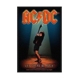 Puede incluir: Un póster rectangular con el logotipo de AC/DC en naranja y amarillo en la parte superior. Debajo, un guitarrista con ropa negra toca bajo un foco. El texto LET THERE BE ROCK aparece en la parte inferior, seguido de información de copyright.