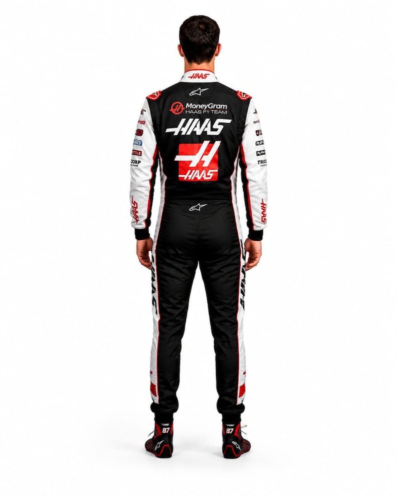 Puede incluir: Mono de carreras en blanco y negro con detalles rojos, con el logotipo del equipo Haas F1 y logotipos de patrocinadores. El mono tiene el n&uacute;mero 44 en la espalda y se usa con zapatos de carreras negros y rojos.