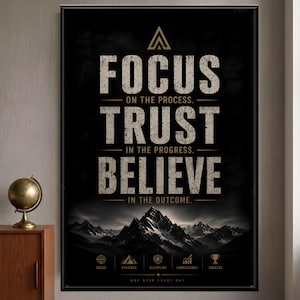 May include: A rectangular wall art print with a black background featuring the text FOCUS ON THE PROCESS, TRUST IN THE PROGRESS, and BELIEVE IN THE OUTCOME in white. Below the text is a mountain range illustration and five small gold icons.