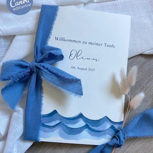 May include: A cream-colored invitation with blue watercolor waves and a blue ribbon. The invitation reads "Willkommen zu meiner Taufe" and "Oliver" with the date "06. August 2027". The Canva logo is in the upper left corner.