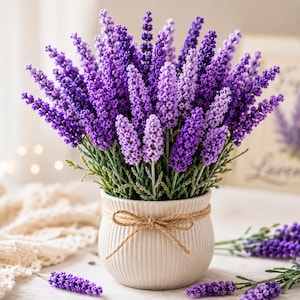 May include: A bouquet of vibrant purple lavender stems arranged in a round, cream-colored ceramic pot with vertical ridges. The pot is decorated with a simple brown twine bow tied around its center, holding the dense cluster of floral stems.