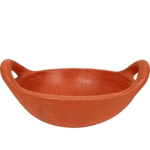 May include: A terracotta-colored, shallow bowl with two loop handles. The bowl has a wide, open design and a smooth, unglazed surface. This earthenware bowl is suitable for serving or display.