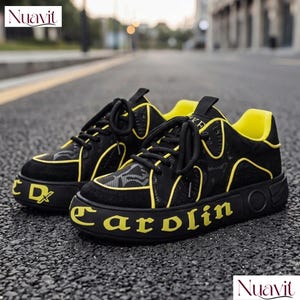 May include: Black and yellow sneakers with the word "Carolin" in yellow on the sole. The sneakers have black laces and a yellow interior. The shoes are on an asphalt surface.