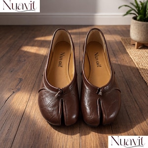 May include: A pair of brown leather split-toe ballet flats. The shoes feature a rounded toe design with a split between the big toe and the other toes. The brand name "Nuavait" is printed on the insole and the top of the image.