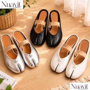 May include: Three pairs of slip-on shoes in black, silver, and white. Each shoe features a split-toe design, a tan elastic strap across the instep with a frayed edge, and a small decorative knot detail at the center of the vamp near the toe split.