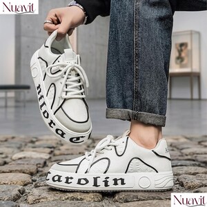 May include: White sneakers with black accents and the word "carolin" printed on the side. The shoes have white laces and a thick sole. The word "nildora" is printed on the side of the other shoe. The shoes are being held up by a person.