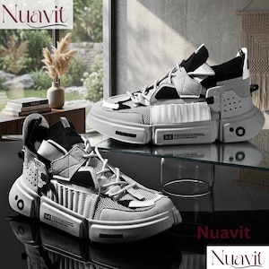 May include: A pair of modern, gray and white sneakers with a chunky sole. The shoes feature a mix of materials, including mesh and suede, with a unique geometric design. The brand name "Nuavit" is displayed in the upper left and lower right corners.