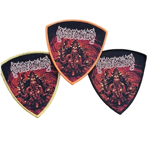 May include: Three shield-shaped patches with the word "Dissection" in white, gothic-style lettering. Each patch features a red and orange illustration of a demonic figure. The patches have black backgrounds with orange, gold, and black borders.