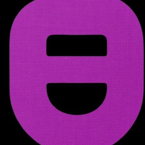 May include: A close-up of a purple, oval-shaped object with a textured surface. The object has two rectangular cutouts and a semi-circular cutout at the bottom, set against a black background.