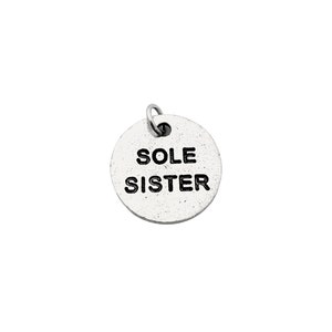 May include: Silver charm with the words "Sole Sister" engraved on it.