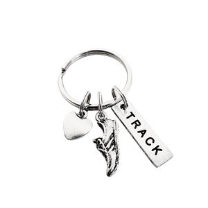 May include: Silver key chain with three charms: a heart, a running shoe, and a tag that says "TRACK".