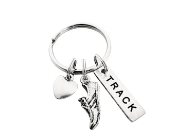 May include: Silver key chain with three charms: a heart, a running shoe, and a tag that says "TRACK".