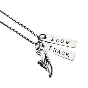 May include: A silver necklace with a running shoe charm and two tags that read "200 M" and "TRACK".