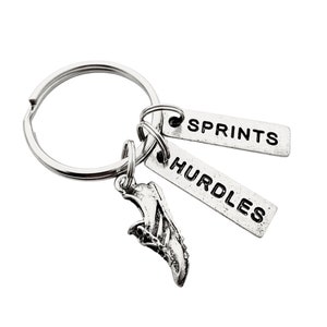 May include: Silver keychain with a running shoe charm and two tags that say "SPRINTS" and "HURDLES".